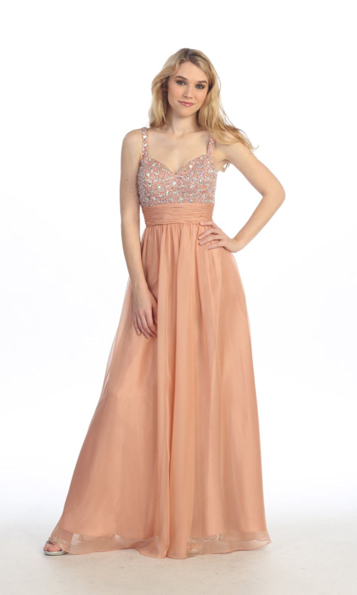 A woman models the Empire-Waist Long Prom Dress: Chicas C7816, a sleeveless peach gown with a beaded bodice and flowing skirt, standing against a plain white background.